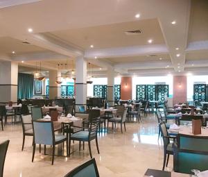 a restaurant with tables and chairs in a room at Royal Thalassa Monastir in Monastir