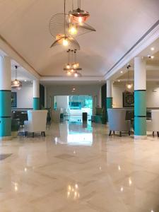 a large lobby with white chairs and blue columns at Royal Thalassa Monastir in Monastir