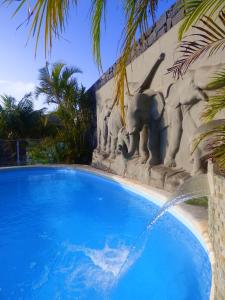 a swimming pool with a statue next to a building at Eco Suites Caves in La Laguna