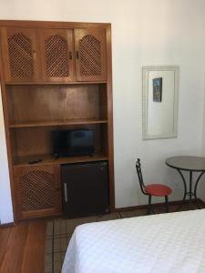 a bedroom with a bed and a tv and a table at Turis Hotel in Santo Ângelo