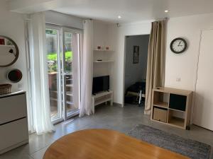 a living room with a clock on the wall at Rez de Jardin Terrasse Literie Haut de gamme Proche Gare et Hyper Centre in Quimper