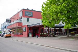 a red and white building on the side of a street at Jennys Hotell och Restaurang in Arvika