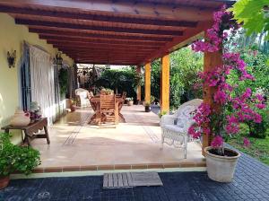 un patio con sillas y una mesa con flores púrpuras en Casa la Gaspareta, en Beniarbeig