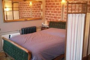 Bett in einem Zimmer mit Ziegelwand in der Unterkunft Charming old style in Honfleur