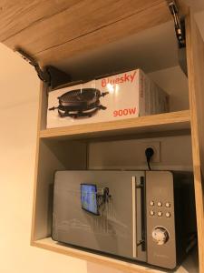 a box on a shelf next to a refrigerator at Le petit nid de chessy in Chessy