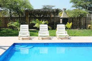2 chaises longues et une piscine dans l'établissement Hotel Casa Vichayo, à Vichayito