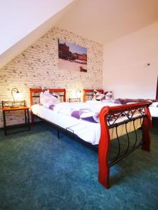 um quarto com uma cama grande e uma parede de tijolos em Casa Mia Pension am Mailandsberg - Klima em Lutherstadt Wittenberg