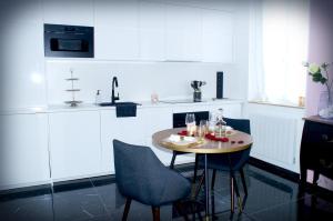 a kitchen with a small table and chairs in it at Le Vénus - Appartement SPA Privatif Balnéo Sauna in Dijon