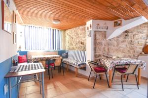 um restaurante com mesas e cadeiras e uma parede de pedra em Sailor House em Budva