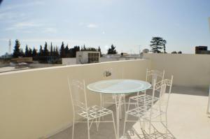 une table et des chaises sur le toit d'un bâtiment dans l'établissement Cosy Triplex in La Marsa - 3 bed 2 Bath, à La Marsa