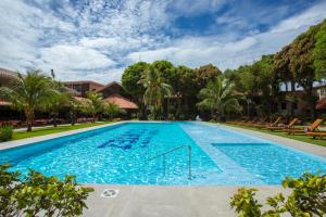 una gran piscina con agua azul y palmeras en Hotel Cortez, en Santa Cruz de la Sierra