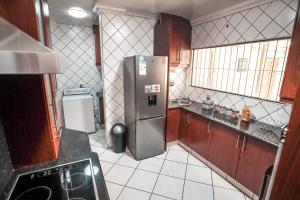 a small kitchen with a stainless steel refrigerator at Menlyn Maine: The Exquisite Lunette in Pretoria