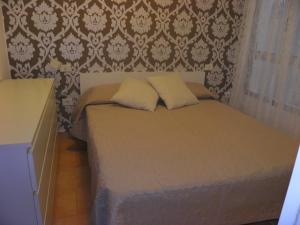 SardinaにあるApartamento en playa de Sardinaの壁付きのベッドルームに枕2つが備わるベッド1台