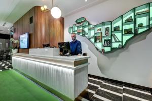 a man standing at a counter in a lobby at Hôtel Uville Montréal in Montréal