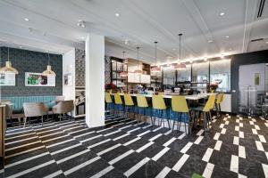 蒙特婁的住宿－Hôtel Uville Montréal，餐厅设有格子地板和黄色酒吧凳子