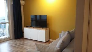 ein Wohnzimmer mit einem Sofa und einem TV auf einem Schrank in der Unterkunft Apartament Katowice Centrum in Kattowitz