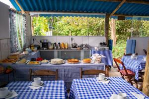 a restaurant with two tables and a counter with food on it at João e Maria Restaurante e Chalés in Tiradentes