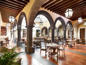 un restaurant avec des arches, des tables et des chaises dans l'établissement Hotel Solar de las Animas, à Tequila