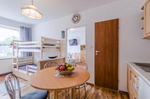 a kitchen with a table with a bowl of fruit on it at Pokoje Malgo Ustka in Ustka