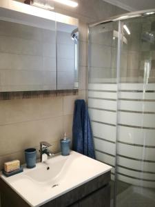 a bathroom with a sink and a shower at Maria's modern studio 5min from beach in Souda