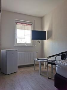 a living room with a tv and a table at Pension Stamperl Bar in Vohburg an der Donau +8 photos