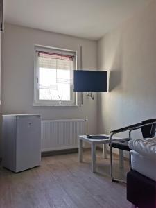 ein Wohnzimmer mit einem TV und einem Tisch in der Unterkunft Pension Stamperl Bar in Vohburg an der Donau
