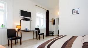 ブラチスラヴァにあるLEO Apartment Obchodna - Deluxのベッドとテレビ付きの机のある寝室