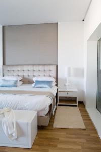 a white bedroom with two beds and a table at Royal Thalassa Monastir in Monastir