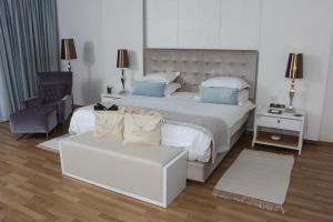 a bedroom with a bed and a chair and a couch at Royal Thalassa Monastir in Monastir