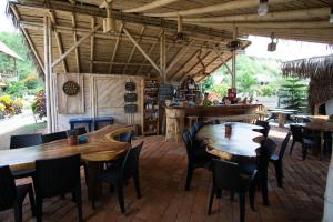 comedor con mesas y sillas de madera en Canoa Suites, en Canoa