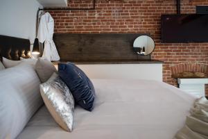a bed with white pillows and a brick wall at 48 King West in Brockville