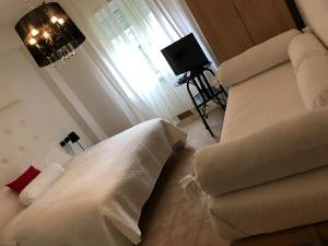 a bedroom with a bed and a couch and a window at Ascoli Bonjour b&b & Apartments Parcheggio Privato & Giardino in Ascoli Piceno