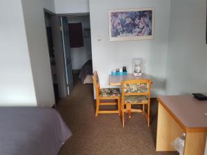 a small room with a table and a chair at Anchor Riverfront Motel in Sicamous