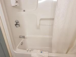 a white bath tub sitting next to a white toilet at Anchor Riverfront Motel in Sicamous
