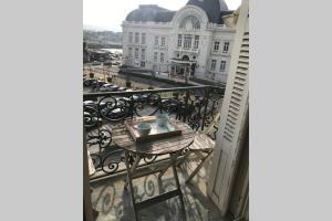 a table on a balcony with a view of a building at Le studio de la mer in Trouville-sur-Mer