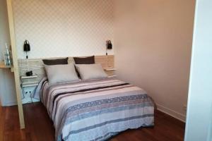 a bedroom with a bed with two pillows on it at Le studio de la mer in Trouville-sur-Mer
