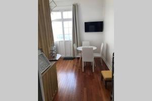 a living room with a table and a window at Le studio de la mer in Trouville-sur-Mer
