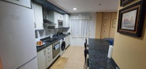 uma cozinha com um lavatório e um fogão forno superior em Acuarium 1 em Gijón