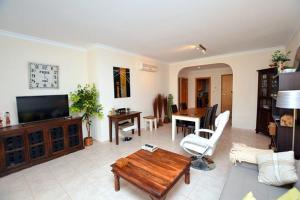 a living room with a tv and a table and a couch at CONDOMINIO LOS OLIVOS DEL GOLF in Faro