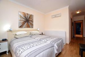 1 dormitorio con 1 cama grande y una pintura en la pared en CONDOMINIO LOS OLIVOS DEL GOLF en Faro