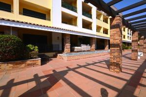 a courtyard of a building with a brick pillar at CONDOMINIO LOS OLIVOS DEL GOLF in Faro