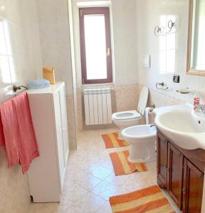 y baño con aseo blanco y lavamanos. en Graziosa Camera privata vista mare in centro, en Peschici