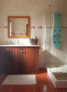a bathroom with a sink and a shower with a mirror at Azores Bagus Surf House in Ponta Delgada