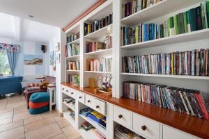 een bibliotheek met witte boekenplanken gevuld met boeken bij Villa Baltic Chałupy Apartament 4 in Chałupy