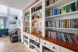 a library with white book shelves filled with books at Villa Baltic Chałupy Apartament 4 in Chałupy