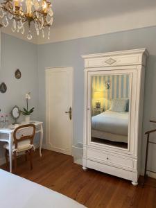 a bedroom with a bed and a table and a mirror at La Croix Blanche in Dax