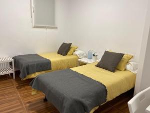 2 Betten in einem kleinen Zimmer mit ermottermott in der Unterkunft Apartamentos el Balcon del Cañon Valdemaluque in Valdemaluque