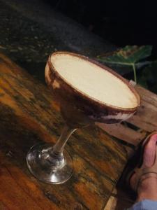 una persona in piedi su un tavolo di legno con un bicchiere da vino di Hostal Mama Tayrona a Santa Marta Altre 37 foto