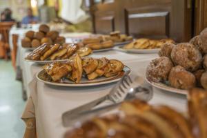 einen Tisch mit Gebäck und Donuts auf in der Unterkunft Gran Hotel Rural Cela in Belmonte de Miranda