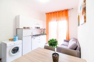 cocina y sala de estar con mesa y sofá en Residence Comfort, en Lido di Jesolo